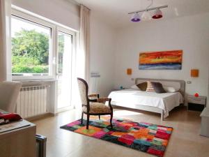 a bedroom with a bed and a chair and a rug at Feudo di Castelmozzo in Santa Paolina