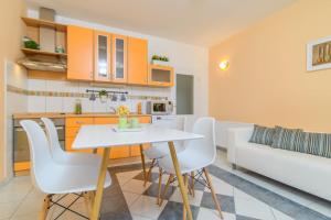 una cucina e un soggiorno con tavolo e sedie bianchi di Apartments Dubravka a Trogir