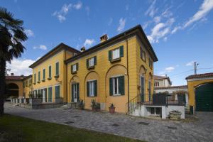 a yellow house with a lot of windows at Foresteria La Torretta in Fino Mornasco