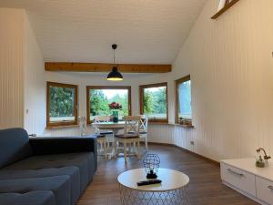 een woonkamer met een bank en een tafel bij Luxus Ferienhaus, direkt am Wald, Terrasse&Garten, Grill, ruhige Lage, WLAN, Wandern, in Wienrode