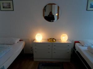 ハイリゲンハーフェンにあるFewo " fáros "のベッドルーム1室(ベッド2台、ドレッサーの照明2つ付)