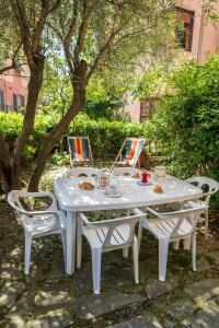 a white table and chairs sitting under a tree at Il Piccolo Gigante in Monterosso al Mare