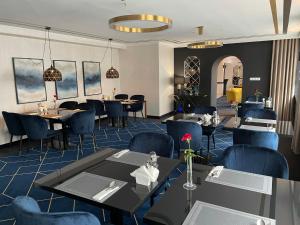 une salle à manger avec des tables et des chaises bleues dans l'établissement Hotel Daria, à Tychy