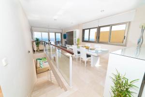 cocina y comedor con paredes y ventanas blancas en VILLA LUXURY VISTA DE MAR en Santa Cruz de Tenerife