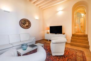 uma sala de estar com um sofá branco e uma televisão em Residenza San Leonardo em Veneza