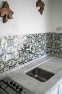 a kitchen counter with a sink and tiles on the wall at Villa Smith in Vernazza
