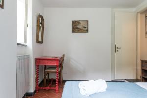 a bedroom with a red table and a bed and a chair at Villa Smith in Vernazza