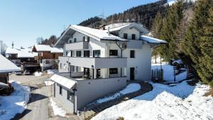 ein weißes Haus mit Schnee auf dem Boden in der Unterkunft Haus Vordertiefenbach in Wagrain