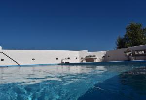 una piscina de agua azul frente a un edificio en Casa Green, en Mijas Costa