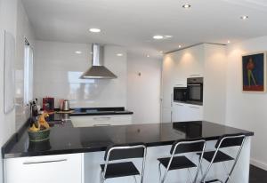 eine Küche mit weißen Schränken und einer schwarzen Arbeitsplatte in der Unterkunft Casa Green in Mijas Costa