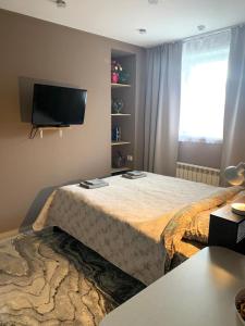 1 dormitorio con 1 cama y TV de pantalla plana en Mini-Hotel Comfort, en Suoyarvi