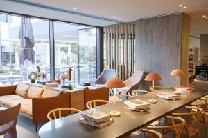 een woonkamer met een bank en tafels en stoelen bij Scandic Frankfurt Museumsufer in Frankfurt am Main