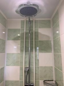 y baño con ducha y ventilador de techo. en Mini-Hotel Comfort, en Suoyarvi