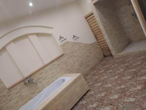 a bathroom with a tub and a tile floor at Jumpravmuižas pirtiņa ar kublu in Mežotne