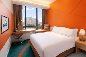 a hotel room with a bed and a desk and window at Days Hotel by Wyndham Singapore at Zhongshan Park in Singapore
