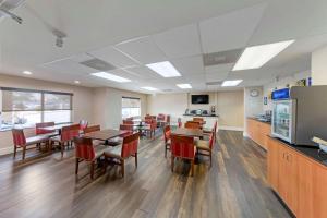 a dining room with tables and chairs and a kitchen at Comfort Suites Victorville-Hesperia in Victorville