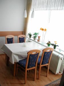 a dining room table and chairs with a white table at Ferienwohnung mit Strandkorb in Heiligenhafen