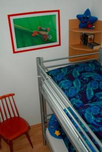 a bedroom with a bunk bed and a red chair at Ferienwohnung mit Strandkorb in Heiligenhafen