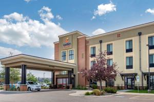 a hotel with a car parked in a parking lot at Comfort Suites Airport-University in Bozeman