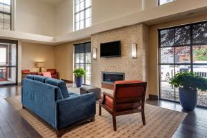 a living room with two blue chairs and a fireplace at Comfort Suites Airport-University in Bozeman