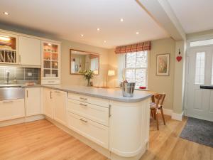 a kitchen with white cabinets and a large island at 2 Kings Yard in Sedbergh