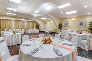 un salón de banquetes con mesas blancas y sillas blancas en Quality Inn & Suites Vestal Binghamton near University, en Vestal