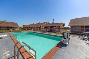 a swimming pool with a bench next to a house at Econo Lodge in Pryor