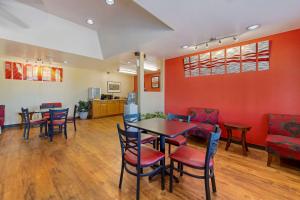 a waiting room with red walls and tables and chairs at Econo Lodge in Pryor