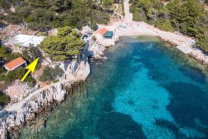 eine Luftansicht auf einen Strand mit gelbem Pfeil in der Unterkunft Seafront Apartments Olivera in Blato