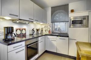 a kitchen with white cabinets and white appliances at Carolin in Zingst