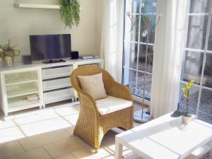 a living room with a wicker chair and a television at Carolin in Zingst