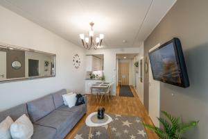 a living room with a couch and a flat screen tv at StarHomes Double lux 7 in Oulu