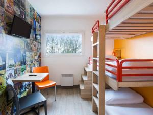 a room with bunk beds with a desk and a table at Hotel F1 Maurepas in Maurepas