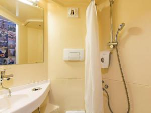 W łazience znajduje się prysznic i umywalka. w obiekcie Hotel F1 Maurepas w mieście Maurepas