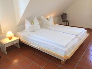 a bedroom with a bed with white sheets and pillows at Ferienparadies Rugana A09 in Kreptitz