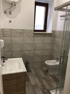 a bathroom with a sink and a toilet and a window at B&B Vittorio Emanuele in Cirò Marina