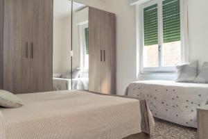 een slaapkamer met 2 bedden en een spiegel bij Il Mare fra gli Ulivi in Monterosso al Mare
