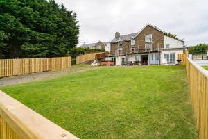 a yard with a fence in front of a house at Bryncarnedd Farmhouse in Aberystwyth