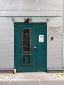 a green door on the side of a building at Happy Inn Hotel Alpiyskiy in Saint Petersburg