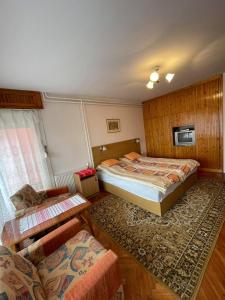 a bedroom with two beds and a table and a couch at Körmendi Apartman in Orosháza