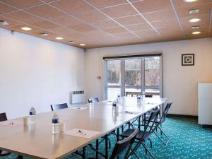 ein großer Konferenzraum mit einem großen Tisch und Stühlen in der Unterkunft hotelF1 Igny Massy TGV in Igny