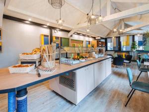 a large kitchen with a counter with fruit on it at Ibis Styles Lyon Croix Rousse in Lyon