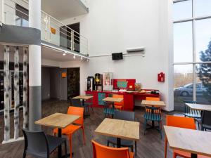 ein Klassenzimmer mit Tischen und Stühlen in einer SchulCafeteria in der Unterkunft hotelF1 Longwy in Longwy