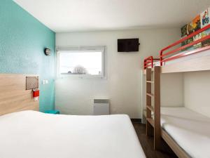 um quarto com 2 beliches e uma janela em hotelF1 Longwy em Longwy