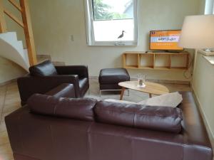 un soggiorno con divano in pelle marrone e tavolo di Appartementhaus Süssling App 2 a Glowe