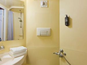 La salle de bains est pourvue d'une douche et d'un lavabo. dans l'établissement ibis budget Le Mans Universite, au Mans