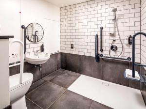 a bathroom with a toilet, sink, and bathtub at ibis London Sutton Point in Sutton
