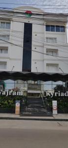 a white building with stairs in front of it at Kyriad Vajram Guntur in Guntūr