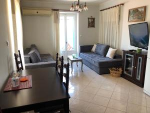 a living room with a couch and a tv at VERANDA BLUE - POROS in Poros