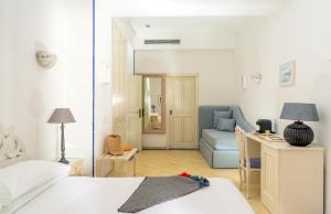 a bedroom with a bed and a desk and a couch at Boutique Hotel Casa Mariantonia in Anacapri